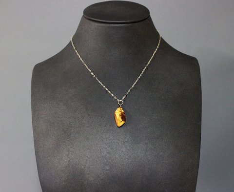 Simpel silverchain with pendant of a piece of amber. 
5000m2 showroom.