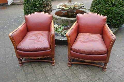 A pair of easy chairs from around the year 1930, in patinated red leather. 
5000m2 showroom.
