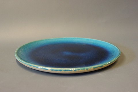 Ceramic plate/round dish with a dark blue glaze by Herman A. Kähler.
5000m2 showroom.