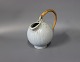 Ceramic jug in light colors with a paper cord handle by Arne Bang.
5000m2 showroom.