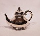 Tea pot of hallmarked silver decorated with grapes and on feet.
5000m2 showroom.